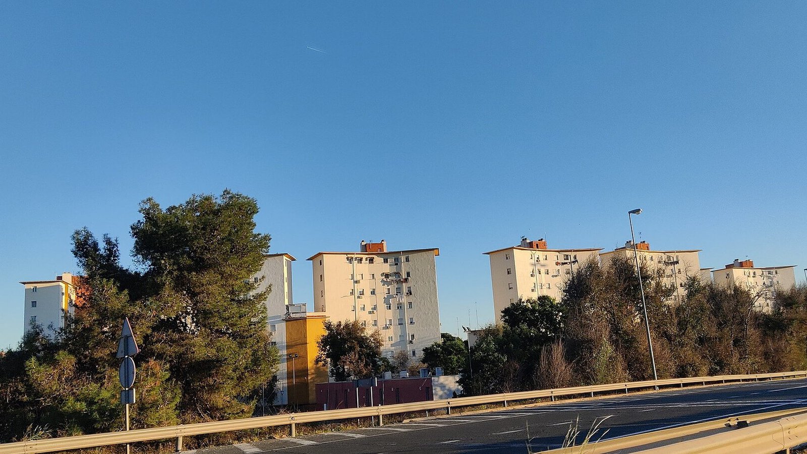 Edificios de un conjunto residencial colombiano vistos desde la calle, en un día de cielo despejado