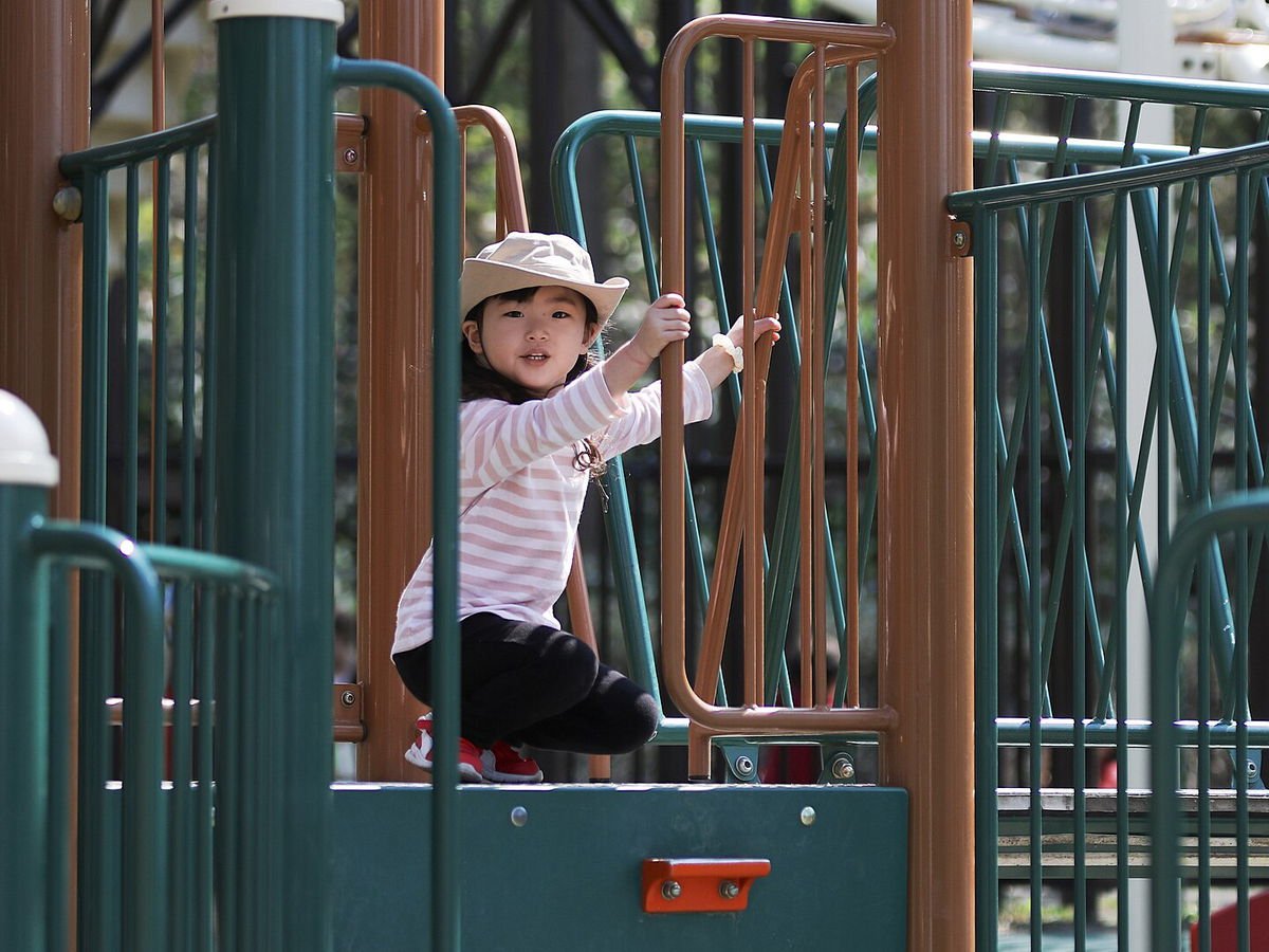 Niña jugando en los juegos infantiles de una zona recreativa